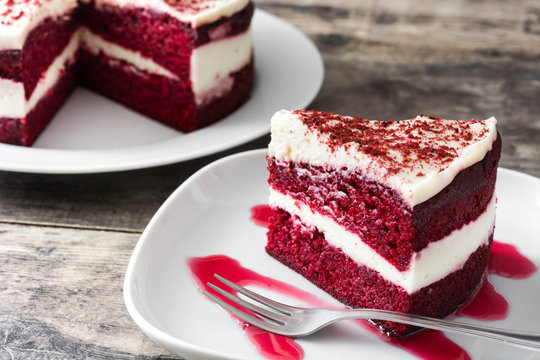 Slice of delicious Red Velvet Cake with creamy frosting on a white plate